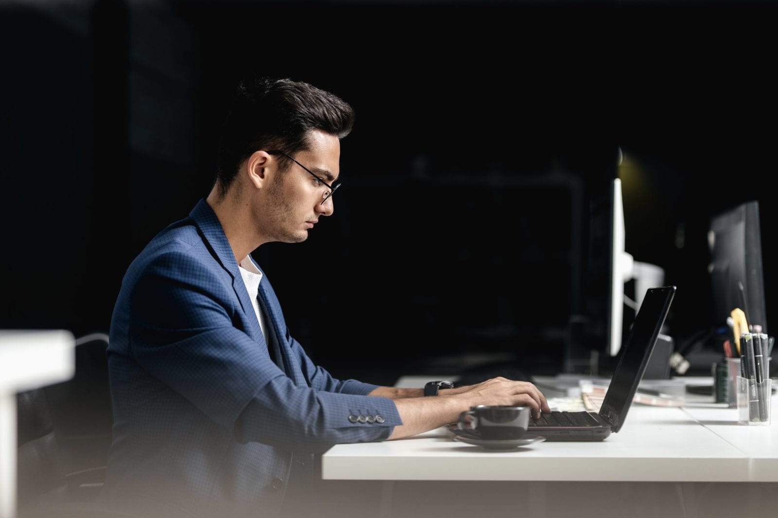 Professional architect dressed in a business suit works on the laptop in the office